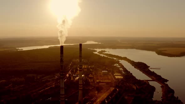 Industrial pipes on nature background. Harmful factory near the lakes in the evening. 