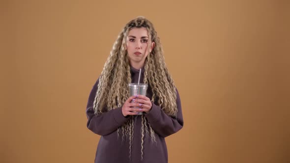 Girl in a Lilac Sweatshirt with a Shiny Glass in Her Hands