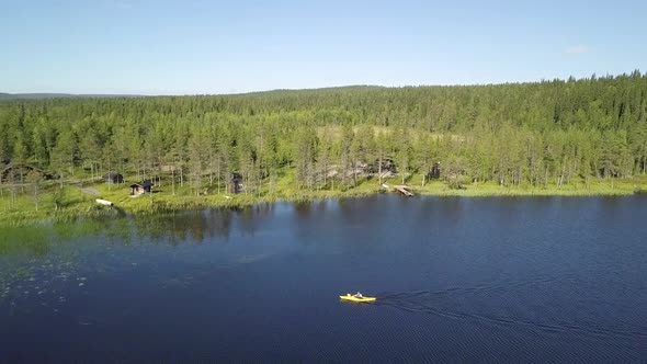 Young male kayaking around in lake Kesankijarvi in Lapland Finland.