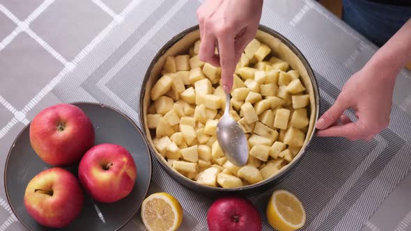 Apple Pie Preparation Series  Woman Pours Chopped Apples Into a Baking Dish