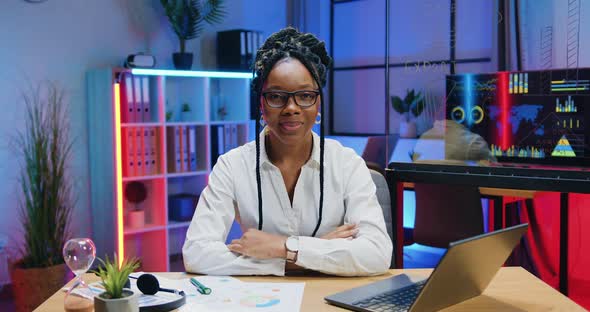 African American Businesswoman in Glasses which Gesturing Thumbs Up Into Camera in Evening Office