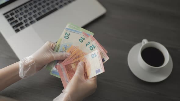 Woman in Protective Gloves Counting Euro Banknotes Money on the Table in Cafe and Working