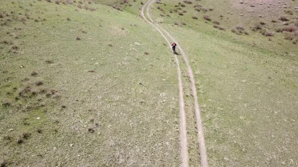 A Group of Cyclists Ride on the Green Steppe