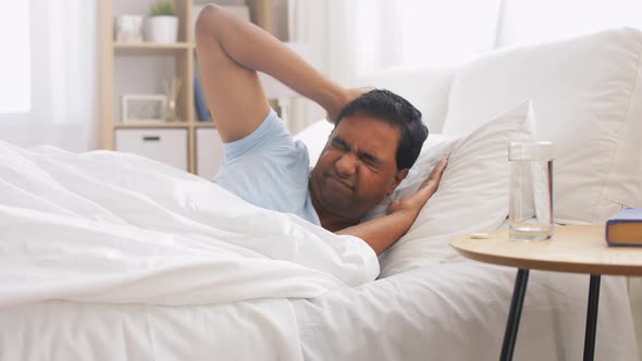 Man in Bed with Medicine and Glass of Water