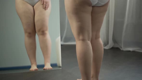 Girl Examining in Mirror Her Sagging Cellulite Body, Pondering About Surgery