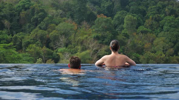 Muscular Guy Swims to Large Pool Edge Kisses Girlfriend