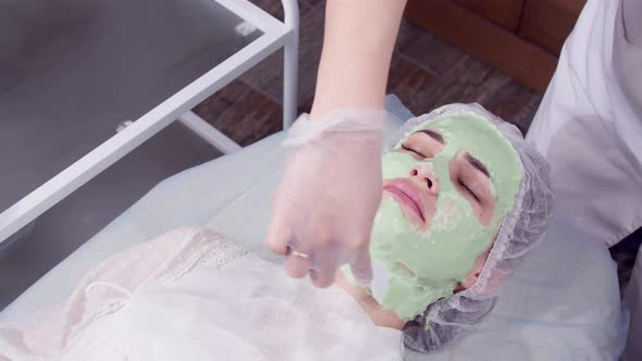 Beauty and Cosmetology Concept. Young Woman with Cream Mask in a Beauty Parlour