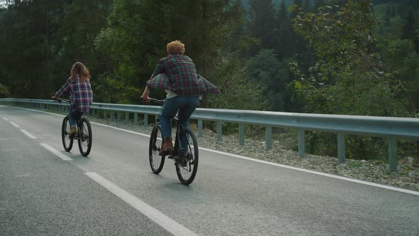 Couple Enjoying Bicycles Trip on Mountains Highway