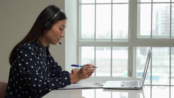 Asian Young Student Use Wireless Earbuds to Have Online Courses and Searching Information Via Laptop