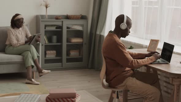 Man and Woman Using Devices at Home