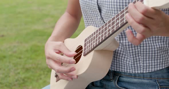 Woman play song on ukulele