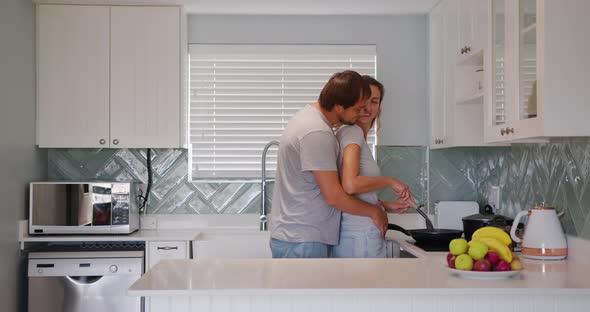 Cheerful Mature Couple Hugging Flirting in Kitchen Having Romantic Relationship