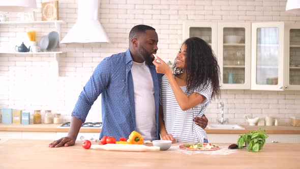 Happy Multiracial Couple Preparing Pizza Together at Home