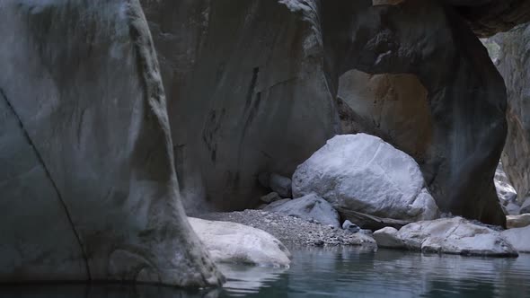 Large Grey Rocky Cliffs of Strange Form Surround Lake Water