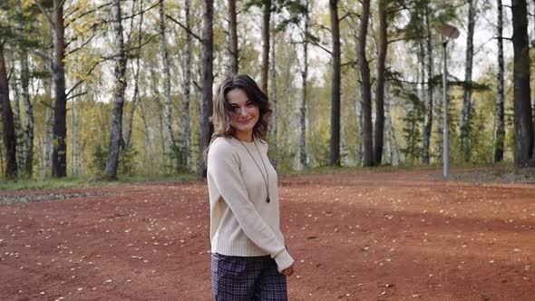 A Young Woman Walks in the Autumn Park. Brunette Woman Jumping and Dancing in the Forest. Freedom