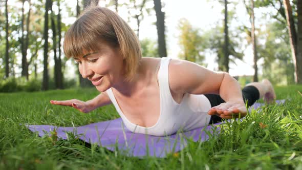 Woman Doing Fitness Exercises on Mat in Local Park