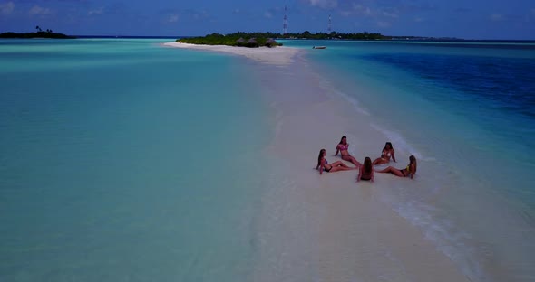 Beautiful happy ladies on vacation enjoying life at the beach on summer white sandy and blue backgro