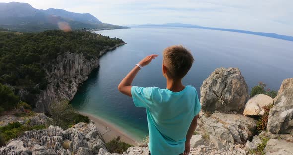 Young 10s-11s Years Traveller with Arms Raised on Top of Mountain Looking at View of Adriatic Sea