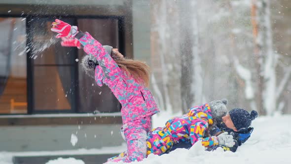 Girl with Mother and Father Plays with Snow in Forest