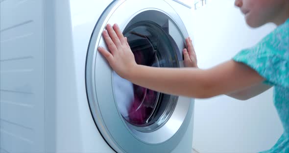 Child Looks Inside the Washing Machine