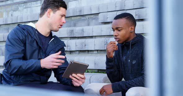 Two disabled athletics discussing over digital tablet 4k