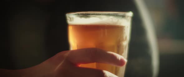 Hand tapping on a glass of beer