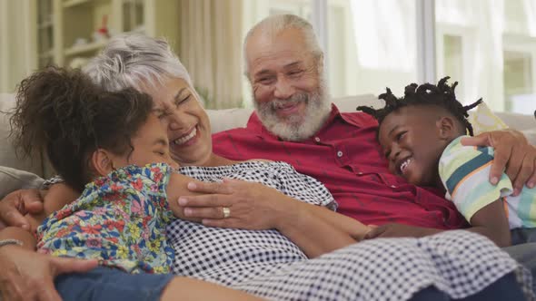 Grandparents embracing their grandchildren at home