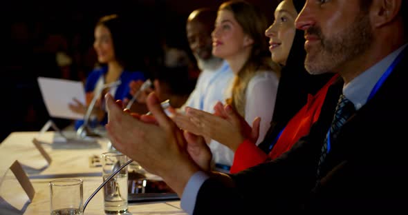 Happy multi-ethnic business people applauding in business seminar in auditorium 4k