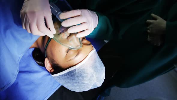 Surgeon putting oxygen mask on patient in operation room