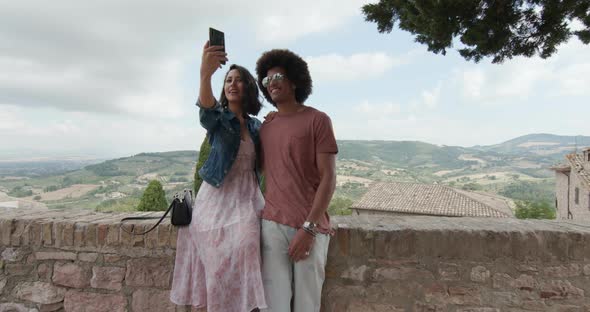 Romantic Couple Taking a Selfie with Smartphone in Rural Town of Assisi.approach Wide shot.Friends