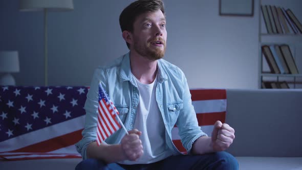 Emotional American Man Waving USA Flag and Watching Election Results on Tv Home