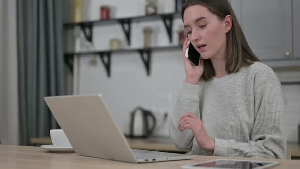 Young Woman Talking on Smartphone in Living Room