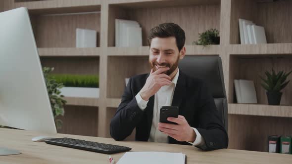 Businessman in Business Suit Laughing While Looking at Phone and Seeing Funny Content or Funny