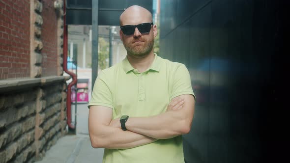 Slow Motion Portrait of Stylish Young Man Standing with Arms Crossed Outdoors Wearing Modern