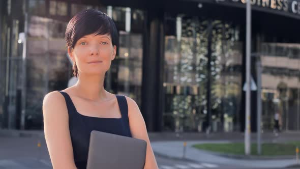 Elegant Brunette Standing in the Morning on the Street