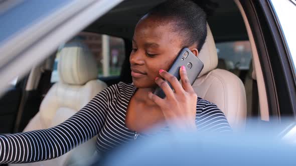 Beautiful African American Woman Talking on the Phone While Sitting in the Car