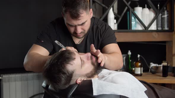 Barber Trimming Beard of Client