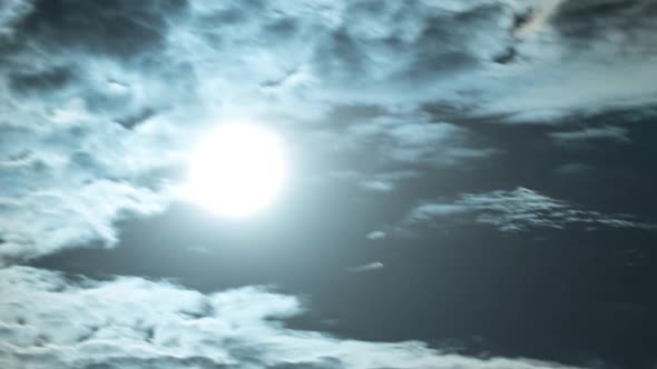 Full Bright Moon Floats Across the Night Sky Among the Clouds