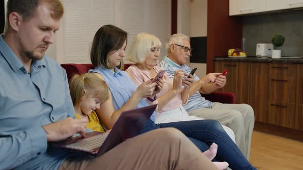 Devices Addicted Family Use Tablet, Mobile Phone Sit on Sofa at Home. Internet Technology Dependence