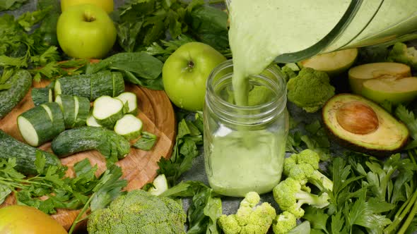 Pouring Organic Freshly Squeezed Green Vegetable and Fruit Smoothie Into the Jar