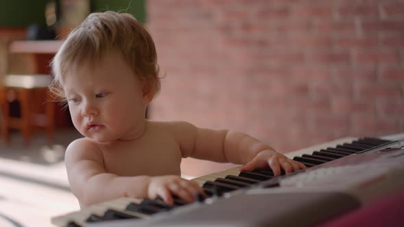 Asian Baby Girl Toddler Playing Electric Piano Sit Down on the Floor Tapping on Keyboard Music