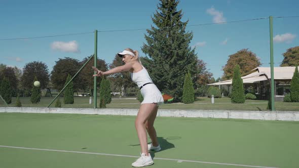 Pro Female Tennis Player Hits the Ball with a Racket Practice Game on the Tennis Court Hits Off the