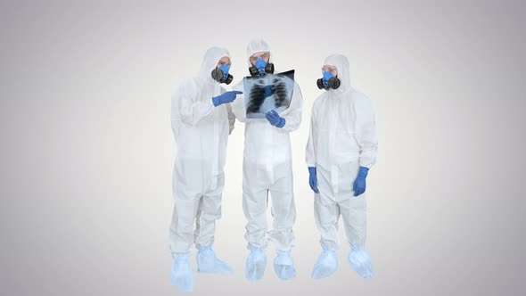 Team of Doctors in Protective Suits Looking at Lungs X-ray on Gradient Background