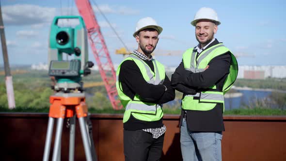 Portrait of Two Confident Young Engineers with Crossed Hands Looking at Camera Smiling Standing on