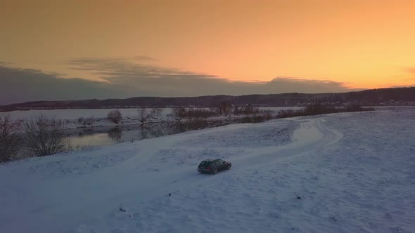 Drone shooting of river against background of a forest and a bridge, a car