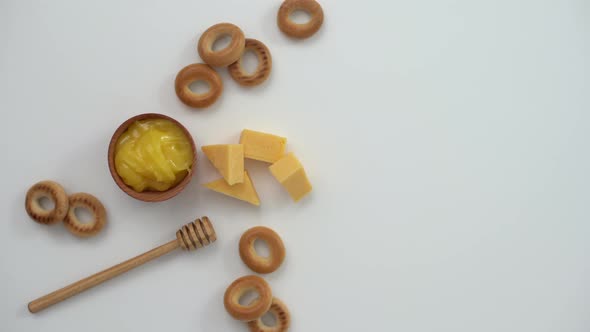 Honey in a Wooden Bowl Bagels and Cheese on a White Background