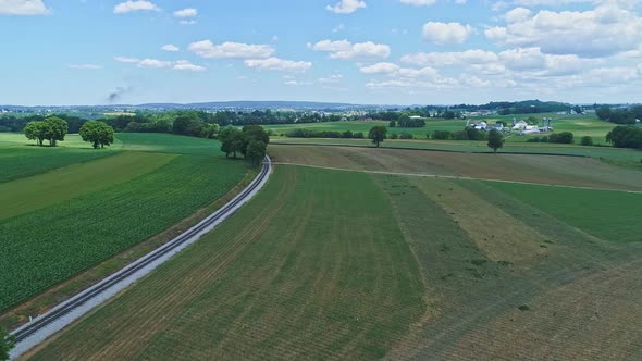 Aerial View of the Farm Countryside With Planted Fields and a Single Rail Road Track