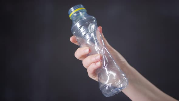 Hand Crumpling Plastic Bottle in Protest