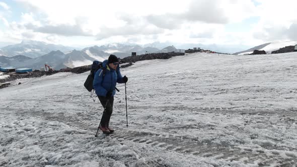 Male mountaineer walking up the snowy slope