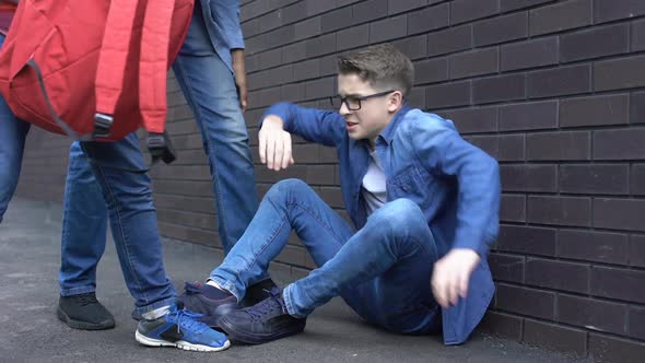 Students Throwing Things Out of Backpack on Boy Head, Teenage Bullying at School